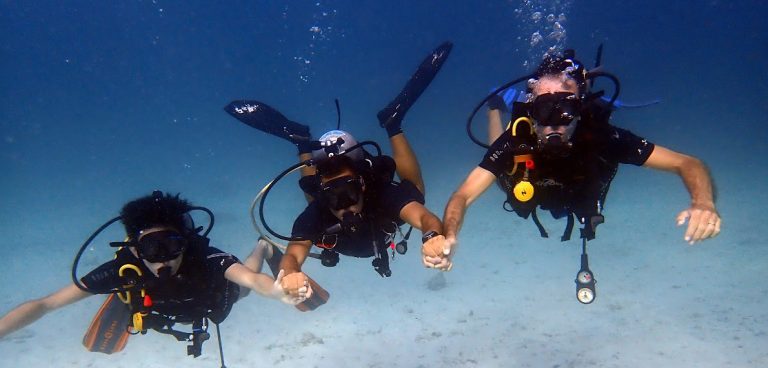Group of first-time scuba divers floating at the surface before descending in Phuket