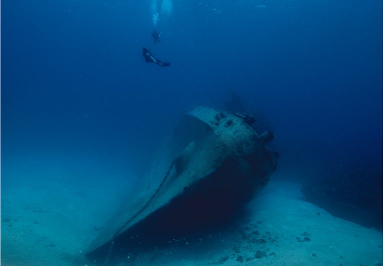 Wreck diver laying guide line before entering shipwreck