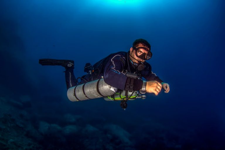 Technical diver exploring coral reef using sidemount gear during Tec course in Phuket