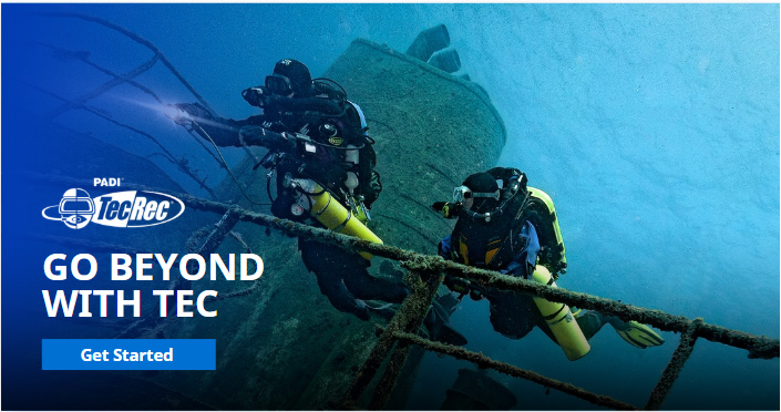 Two technical divers with twin tanks exploring a shipwreck, promoting PADI TecRec courses